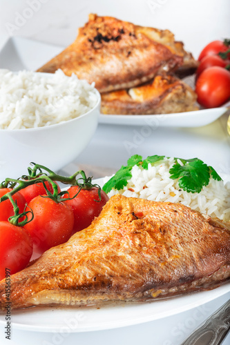 Sea bass grill with rice, greenery and cherry tomatoes. White background.