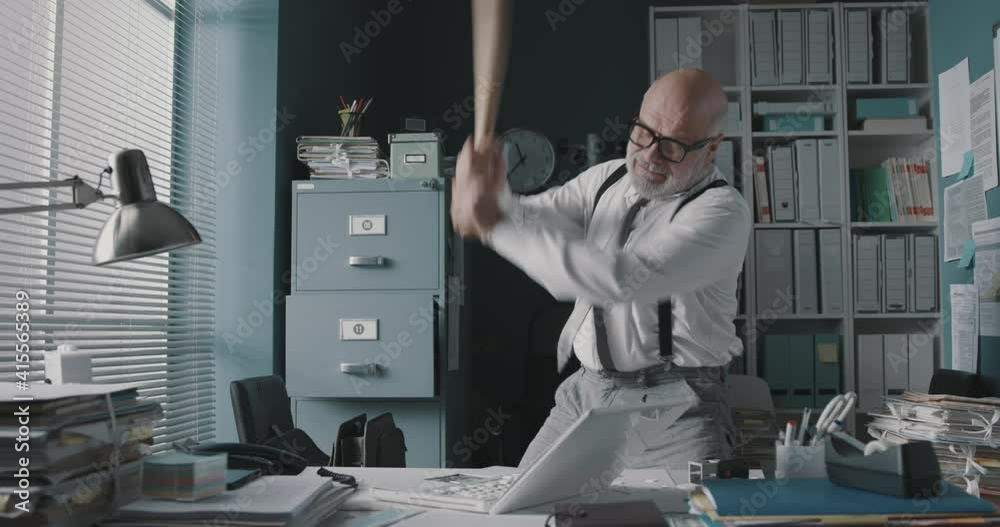 Angry businessman destroying his laptop