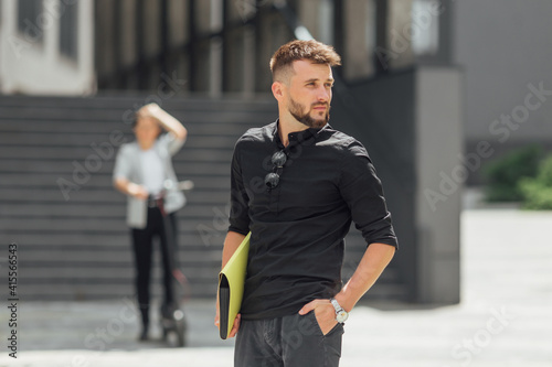 Business man with smartphone is waiting a woman on electric scooter