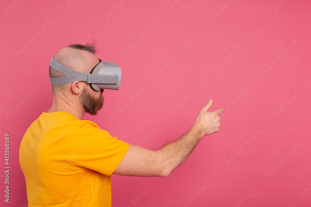 Handsome casual wear men in vr glasses side view pointing to the left text space Handsome casual wear men in vr glasses side view pointing to the left text space