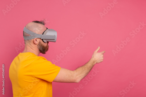 Handsome casual wear men in vr glasses side view pointing to the left text space