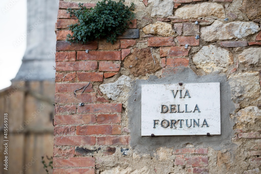Fortune goes on and on. Concept. Fortuna address plate on an old brick background. 