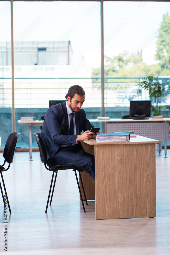 Young male bookkeeper working in the office Young male bookkeeper working in the office