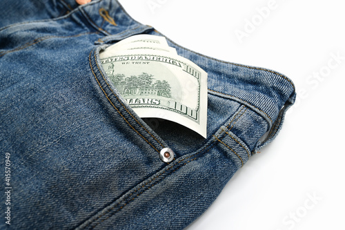 Dollar bills in the front pocket of jeans, on an isolated white background