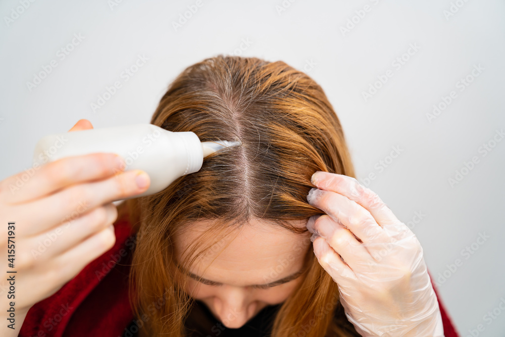 self-coloring the gray roots of hair on the head of a woman. beauty salon and hairdresser. self-coloring the gray roots of hair on the head of a woman. beauty salon and hairdresser.