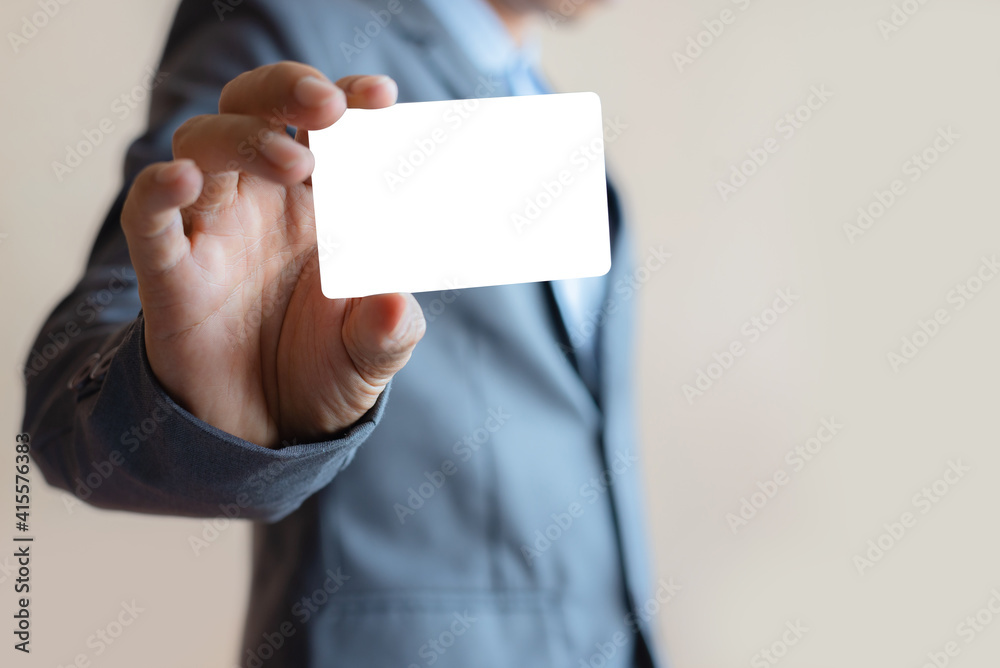 close up attractive business man holding blank white mock up card in hand. close up attractive business man holding blank white mock up card in hand.