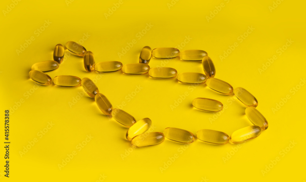 omega 3 gel capsules on yellow background omega 3 gel capsules on yellow background