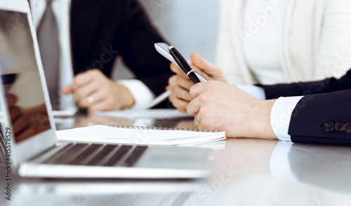 Business people working together at meeting in a modern office. Unknown businessman and woman with colleagues or lawyers at negotiation about contract