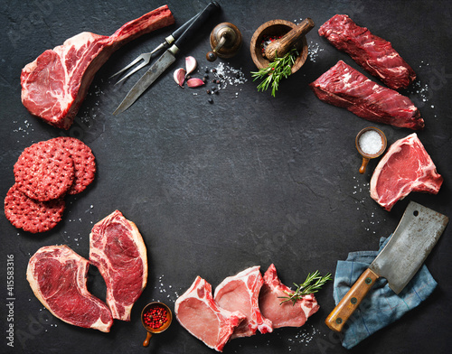 Foto Variety of raw cuts of meat, dry aged beef steaks and hamburger patties