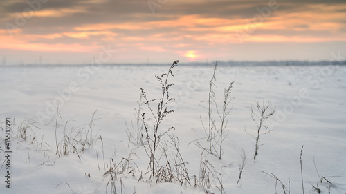 a field covered with snow at sunset