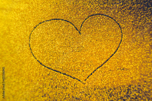 Hand drawn heart on golden sandy background. photo