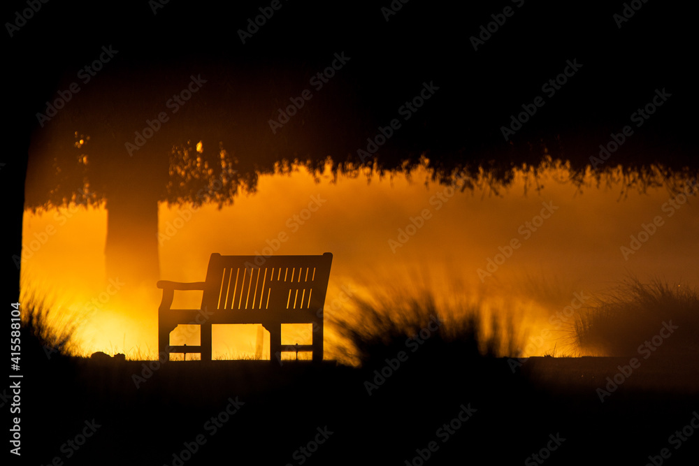 Park bench looking over a mist-laden lake