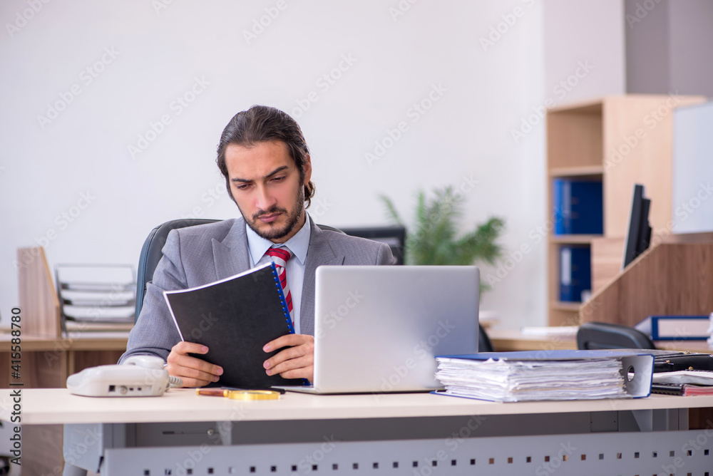 Young male employee working in the office Young male employee working in the office