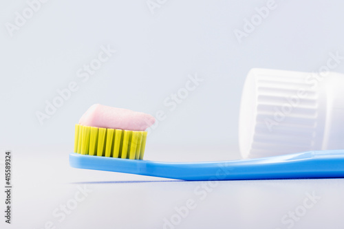 Toothbrush with toothpaste on grey background. Dental concept.