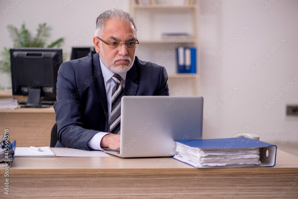 Aged businessman employee sitting in the office Aged businessman employee sitting in the office