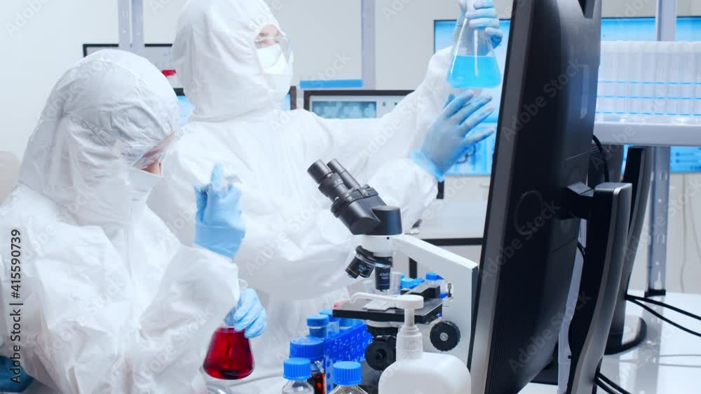 Professional team of scientists is working on a vaccine in a modern scientific research laboratory. Genetic engineer workplace. Future technology and science. Professional team of scientists is working on a vaccine in a modern scientific research laboratory. Genetic engineer workplace. Future technology and science.