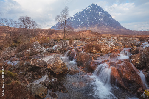 Dramatic landscape of the iconic Buachaille Etiv Mor and River Coupall waterfall at Glencoe in the Scottish Highlands.