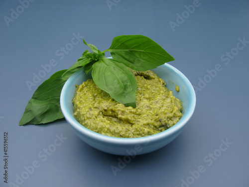 Italian green pesto sauce with basil and arugula in a bowl.