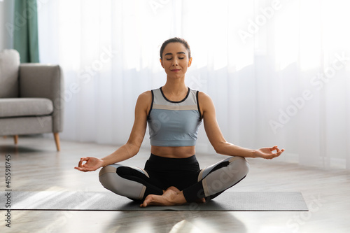 Portrait of young caucasian woman meditating at home