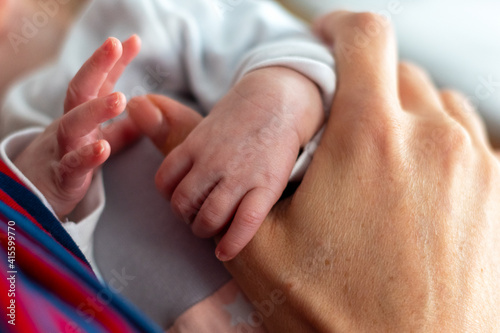 Finger eines Neugeborenen umgreifen den Daumen der Mutter