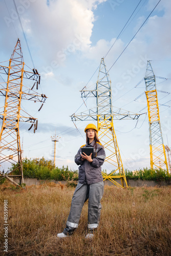 A young engineering worker inspects and controls the equipment of the power line. Energy
