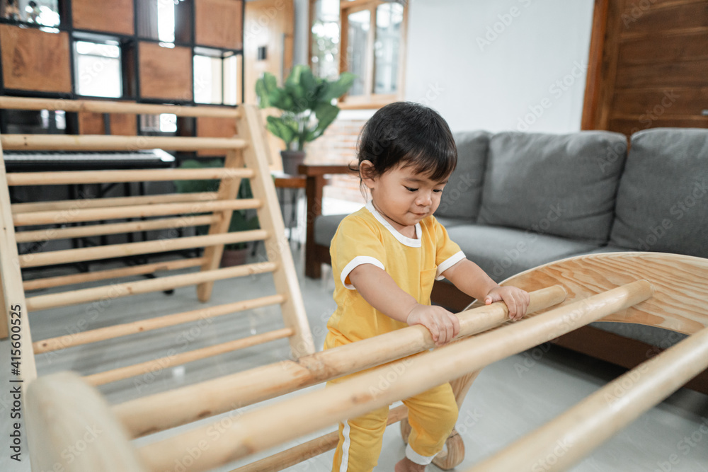 a baby climbing on pikler triangle toys in the home a baby climbing on pikler triangle toys in the home