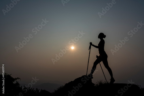 Silhouette Slim Girl of hikers walking in mountains. Woman hiker on a top peak mountain. Life Balance Woman Exercise. Girl adventure fit trekking and happy