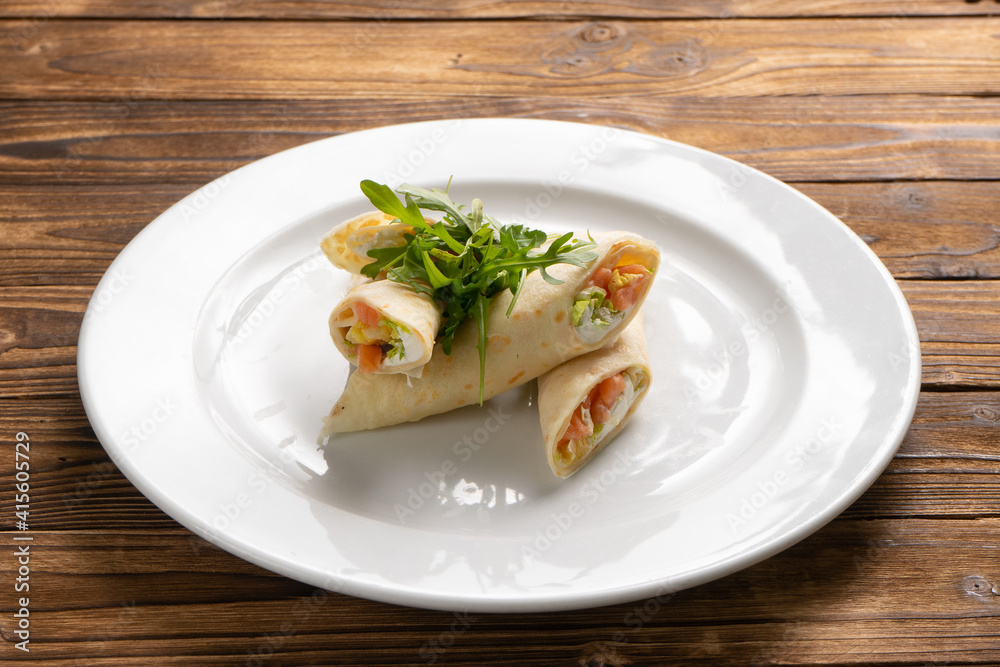 Pancakes with salmon filling, cream cheese, lettuce leaves and arugula.