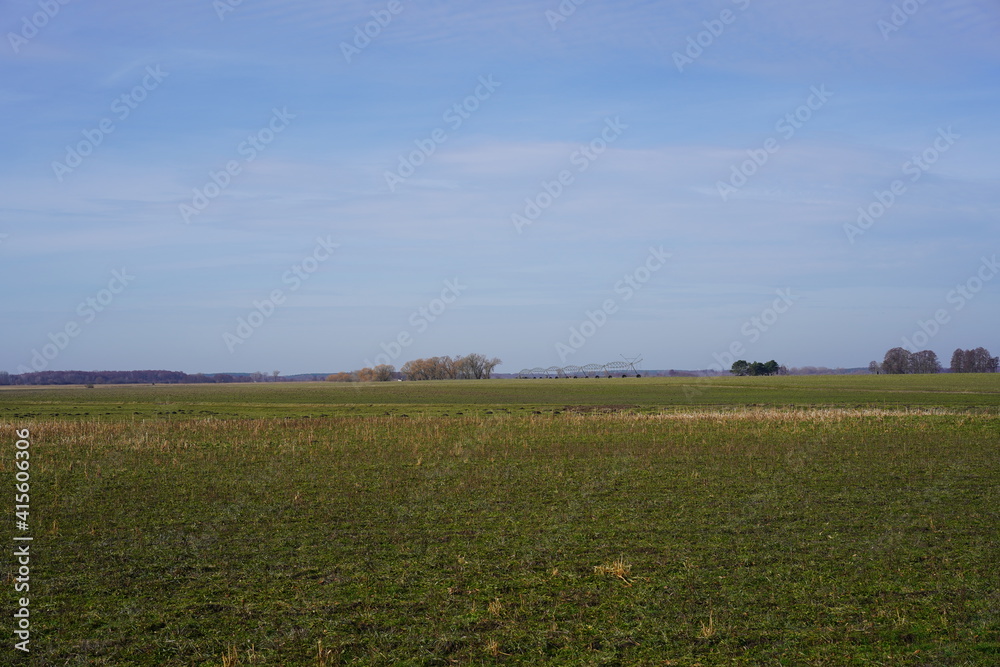 Panoramalandschaft von großen Feldbrachen während der Ruhezeit mit Bewässerungsanlage in Brandenburg
