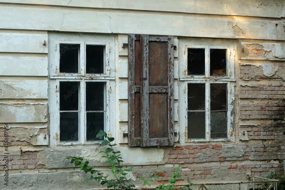 Close-up of two weathering windows of a decaying white house facade
Close-up of two weathering windows of a decaying white house facade