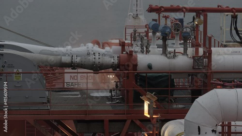 Cold vapour of LNG flange connection on cargo manifold of gas tanker in twilight