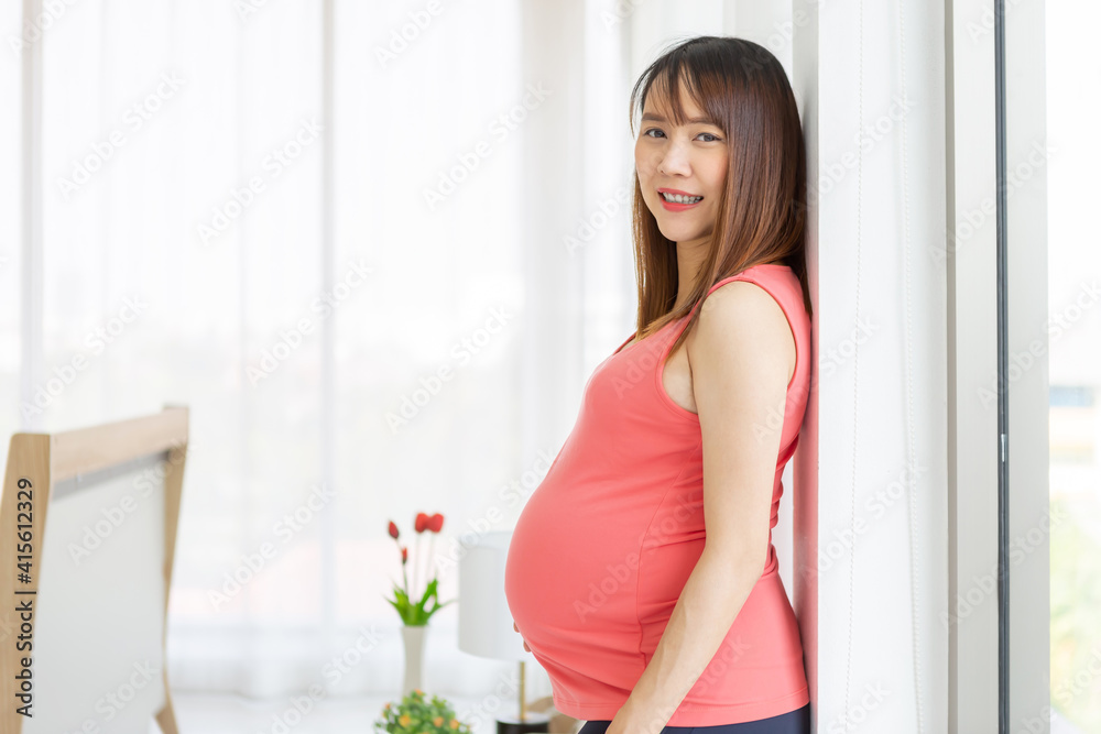 Pregnant woman taking care of her child by holding baby in her pregnant belly in the bedroom
Pregnant woman taking care of her child by holding baby in her pregnant belly in the bedroom