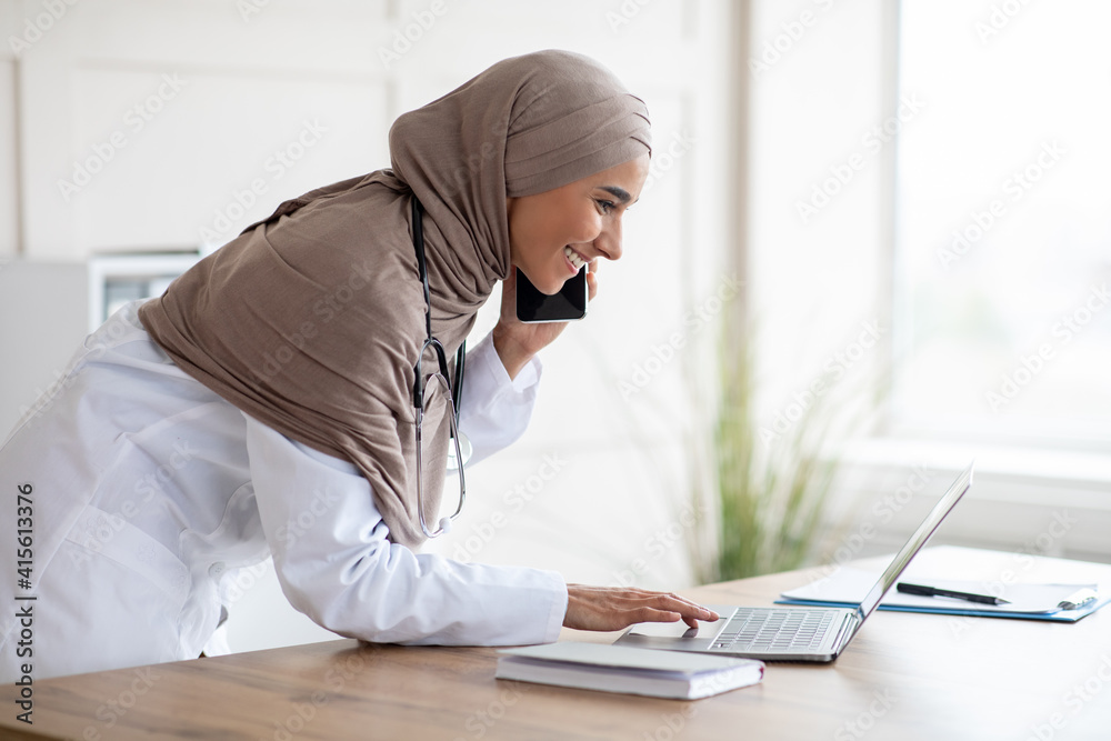 Side view of female doctor arranging appointment on phone Side view of female doctor arranging appointment on phone
