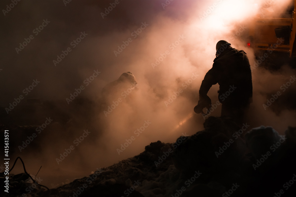 workers of the city utility service fix an accident on the pipeline of heating networks on a frosty winter night workers of the city utility service fix an accident on the pipeline of heating networks on a frosty winter night
