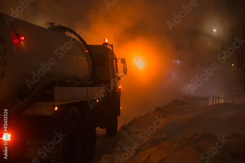 workers of the city utility service fix an accident on the pipeline of heating networks on a frosty winter night