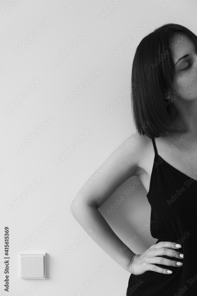 Fototapeta premium Young beautiful woman against white wall. Black and white monochrome beauty, fashion concept.