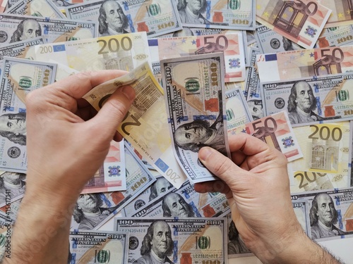Background dollar and euro.Hand holding money.  Hand holding one hundred dollars and two hundred euros.