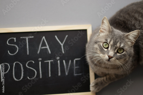 Woman holding a chalkboard with stay positive sign. Motivation.