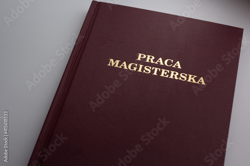 Closeup of Polish Master's Thesis (Praca magisterska) on white background.