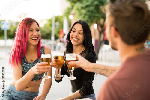 Friends drinking beer having fun in bar terrace with beer
