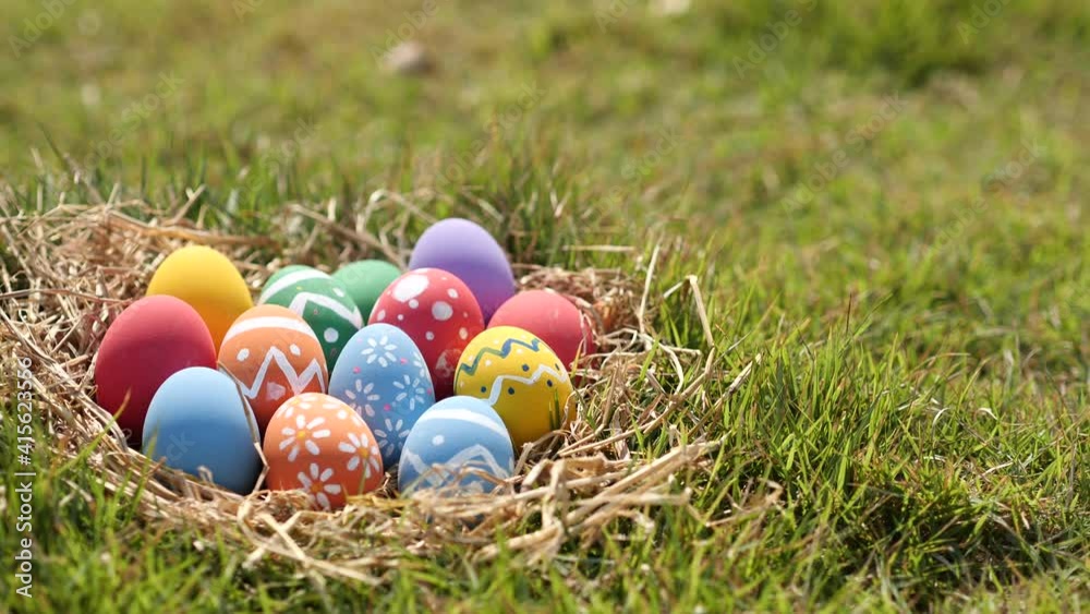 Happy Easter Day. Easter eggs on green grass background, Dolly shot. Camera moving through colorful easter eggs in nest on fresh green grass in morning.