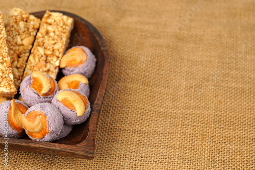  Traditional Thai dessert called Krayasart made from rice, nuts, sesame and sugar with taro cookies in a heart wooden bowl.