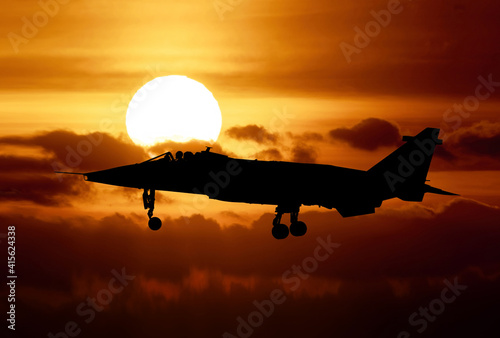 Foto RAF Jaguar strike attack fighter at sunset silhouetted against an orange sky