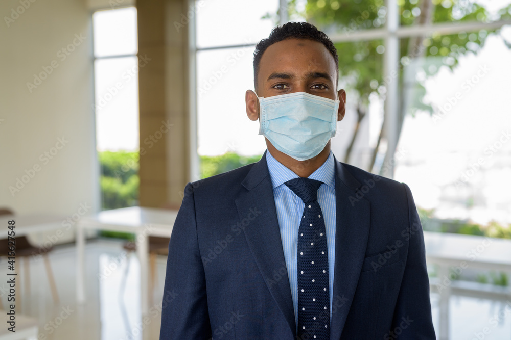 African businessman with surgical medical mask for protection at office African businessman with surgical medical mask for protection at office