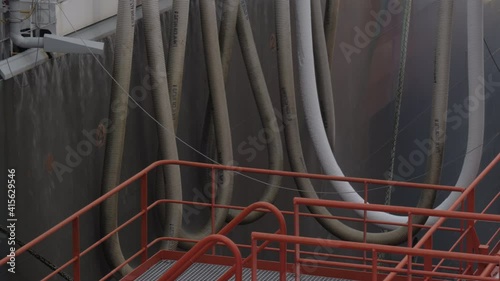 LNG cargo hoses close to hull of large gas tanker