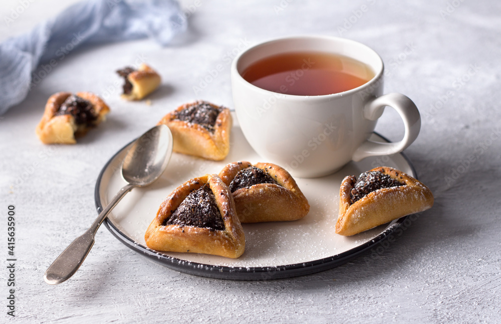 Homemade hamantashen cookies (Haman's ears) with poppy seeds and apples on a light gray background. Traditional pastries for Purim, Jewish carnival Homemade hamantashen cookies (Haman's ears) with poppy seeds and apples on a light gray background. Traditional pastries for Purim, Jewish carnival