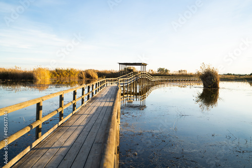 Large wooden pond over the lake of the natural park 'El Hondo' at sunset. Elche, Alicante, Spain.