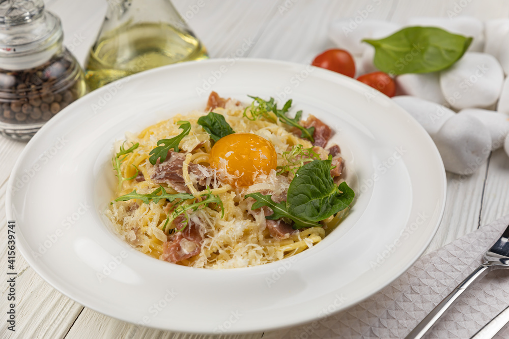 Pasta with egg and parmesan on a white wooden table
Pasta with egg and parmesan on a white wooden table