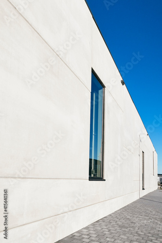 détail d'un mur de façade en béton d'un immeuble moderne avec fenêtre et ciel bleu 
