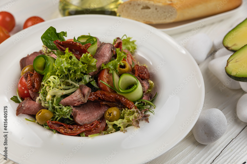 Pasta with herbs and veal on a white wooden table
